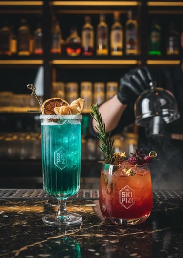 wo vibrant après-ski cocktails, one turquoise and one red, served on a dark marble bar at Ski Pizi w