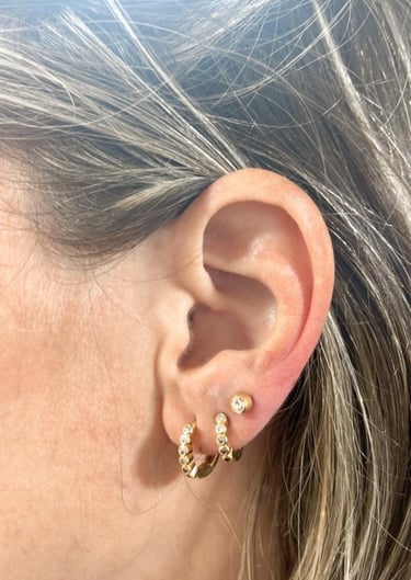 a woman with a gold earring and earrings