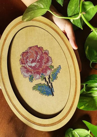 Marco ovalado con bordado de una rosa en punto de cruz 