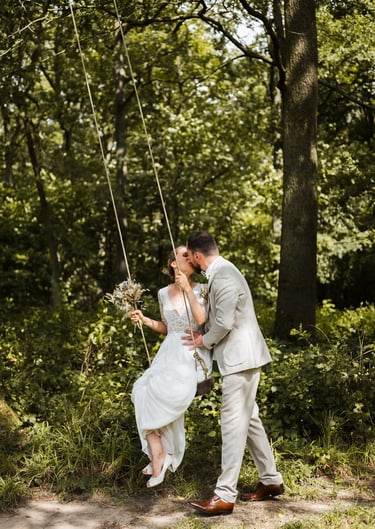 a bride and groom kissing on a swing swing