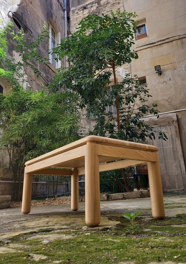 table basse en merisier dans une belle cour avec des plantes