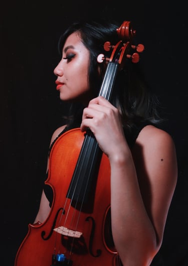 A professional self portrait holding a viola against a black backdrop. 