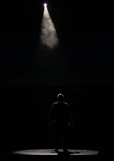 a man standing in front of a spotlight light