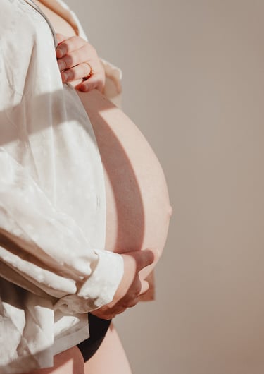 Femme enceinte tenant son ventre portant une chemise