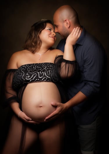 a pregnant woman in a black dress and a man in a black shirt