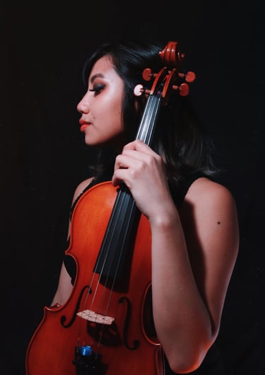 A professional self portrait holding a viola against a black backdrop. 