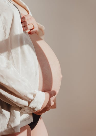 Femme enceinte tenant son ventre portant une chemise