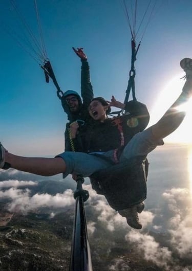 "Excited young woman soaring through the sky during a paragliding feeling the rush of adrenaline