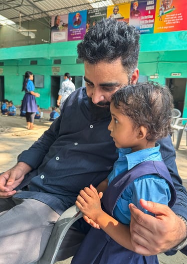 Foundation founder Vikash Sharma holding a child in school uniform during a community outreach program