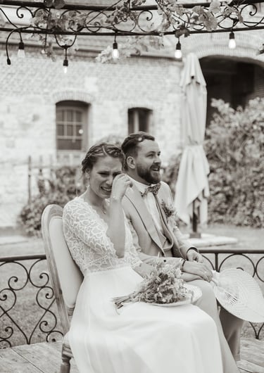 a man and woman sitting on a bench in a garden