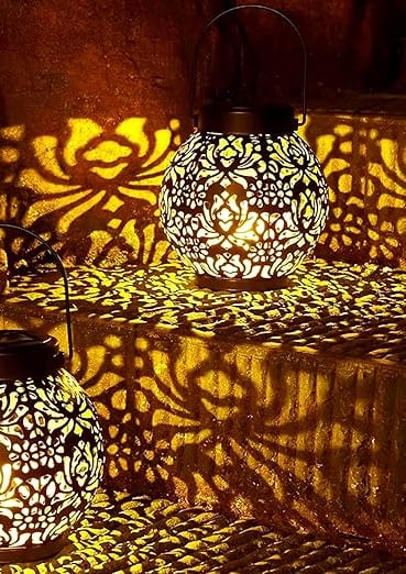 two lanterns with intricate designs on them on a staircase case