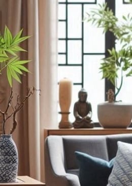 a man sitting at a table with a plant in a vase