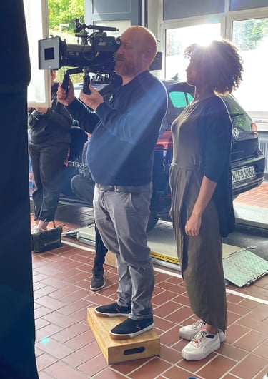 a man and woman standing in front of a camera