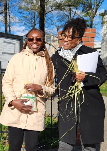 two people standing in front of a fence holding hygiene kits