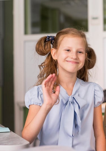 Een meisje in een blauw shirt dat wuift