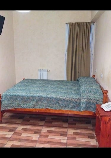 Una habitación con una cama y un televisor