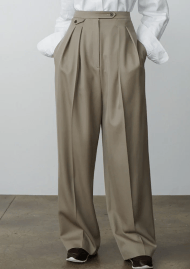 a woman with high-waisted pants and a white shirt