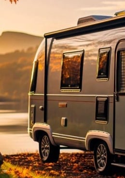 a silver camper trailer parked on a rocky shore