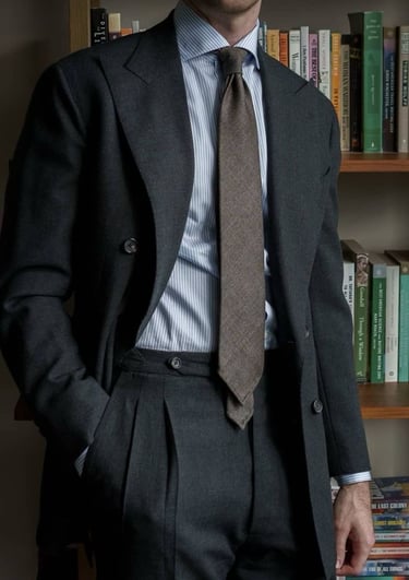 a man in a suit and tie is standing in front of a bookcase