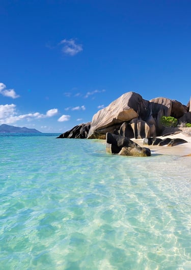 Idyllic Seychelles beach with granite boulders, white sand, and turquoise water.