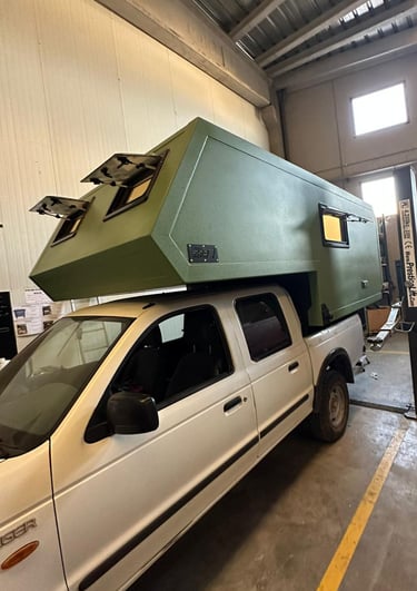 un vehículo pick up verde con cabina camper