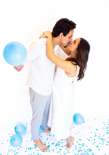 a man and woman kissing in front of balloons