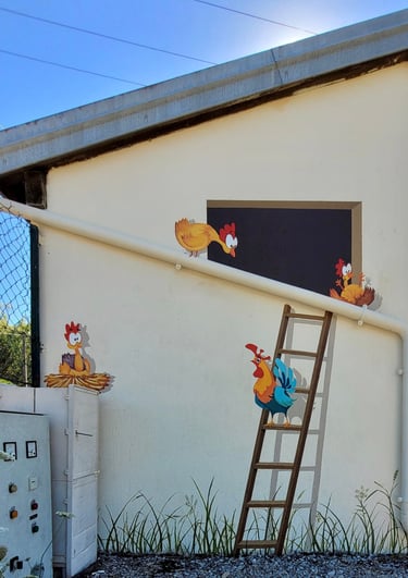 Cette fresque "poulailler" apporte un trait d'humour au mur de cet abri bus en bord de route. De quoi embellir le mobilier ur