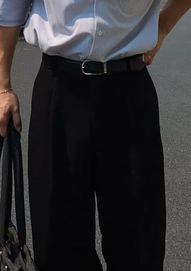 a man in a shirt and pants standing in the street