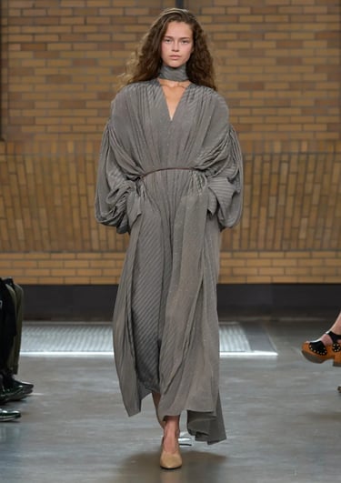 Calvin Klein Spring Summer 2026 runway look with flowing grey maxi dress and scarf detail.