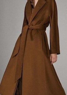 a woman in a long coat and boots