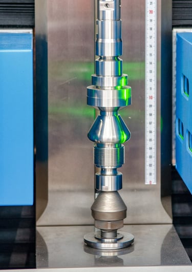 Shaft scanner inspecting a precision shaft using collimated monochromatic light. 