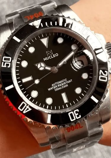 homage submariner acciaio quadrante e lunetta unidirezionale neri con data a ore 3 indossato al polso