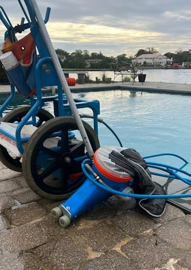 Equipamento profissional de vácuo e manutenção de piscina em um carrinho azul perto de uma piscina n