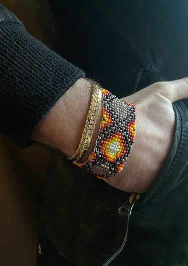 manilla de mostacilla artesanal para hombre en la muneca de la mano metida en el pantalon