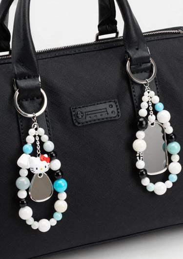 Pair of handcrafted beaded earrings hanging from a natural wooden holder with soft shadows