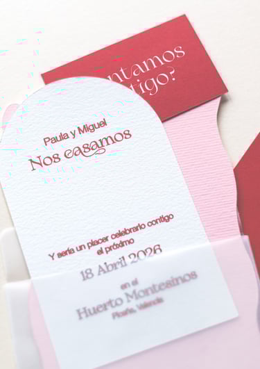 Papeles de diferentes colores y formas que parecen pertenecer a una invitación de boda