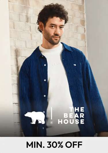 A man wearing a blue pinstripe corduroy shirt from The Bear House over a white sweatshirt.