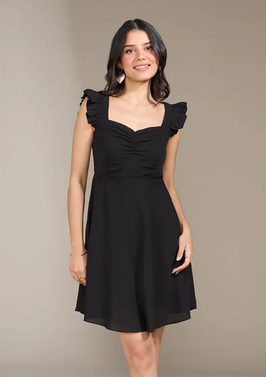 A woman wearing a black ruffle sleeve mini dress with a sweetheart neckline and ruched bodice.