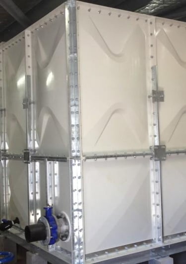 GRP panel water tank installation with galvanized steel frame, ladder access, and piping connections