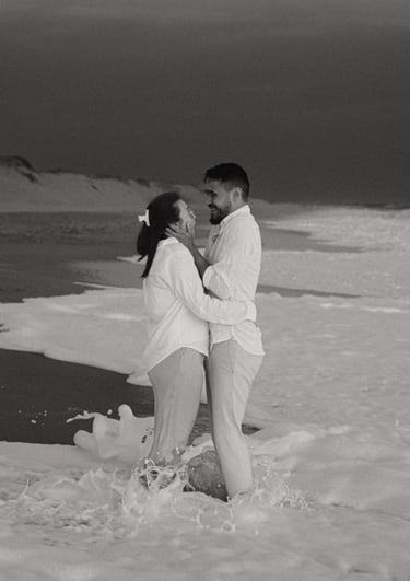 Couple riant les pieds dans les vagues sur une plage de Vendée. Séance photo spontanée et naturelle