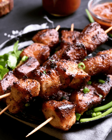 a plate of puerto rican pinchos meat and vegetables on a table