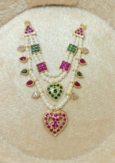 a necklace with a heart shaped pendant and a pearl necklace