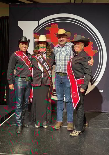Four cowfolks standing on the Royalty stage. Three are in all black and one is in blue.