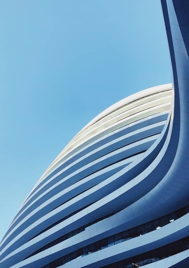 a building with a large curved building in the background