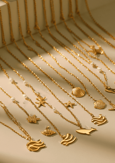 Serie de collares dorados de acero inoxidable alineados con dijes de olas, conchas, estrellas de mar