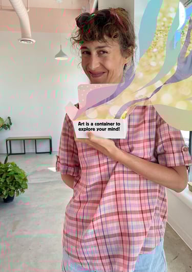 Lisa Cinar is smiling and holding a box that reads "Art is a container to explore your mind!"