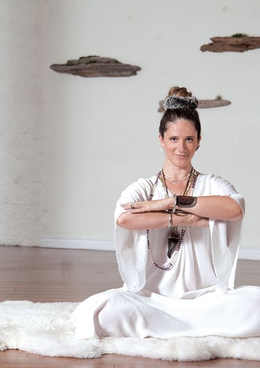 Una mujer sentada sobre una piel de oveja para yoga