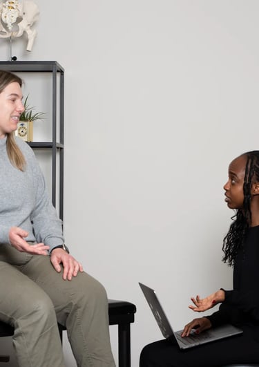 Practitioner explaining osteopathy to a patient on treatment table in JD Osteopathy Mississauga