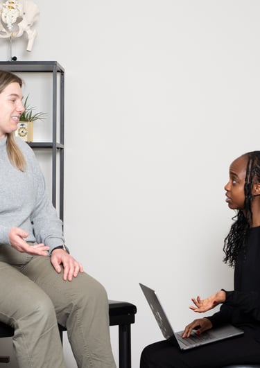 Practitioner explaining osteopathy to a patient on treatment table in JD Osteopathy Mississauga