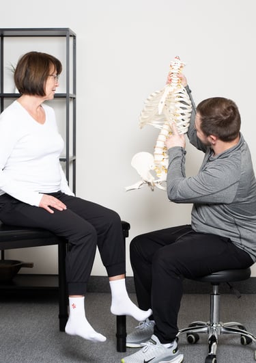 Practitioner illustrating on a model spine to the patient at JD Osteopathy Mississauga